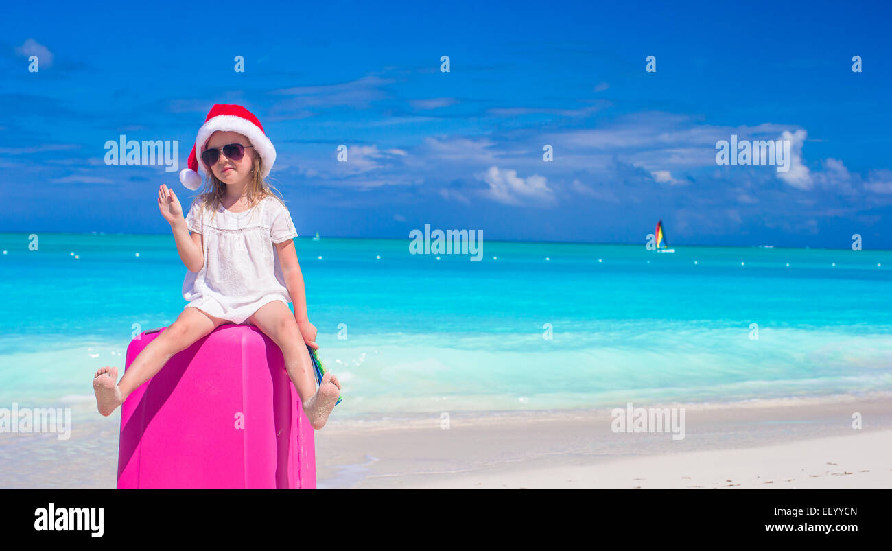 Little cute girl in Santa hat on suitcase at tropical beach Stock Photo ...