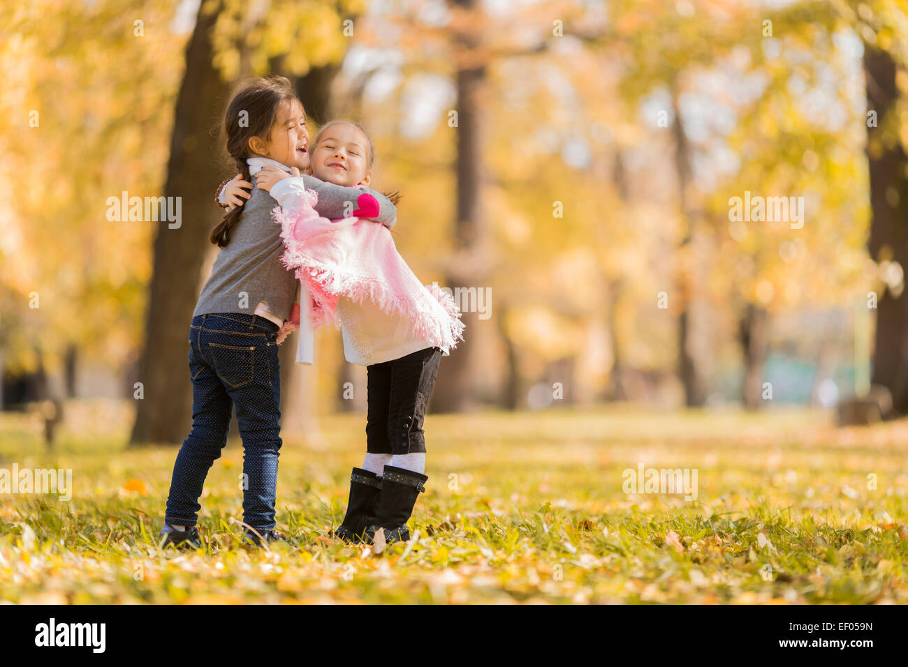 Cute little girls in the autumn park Stock Photo - Alamy