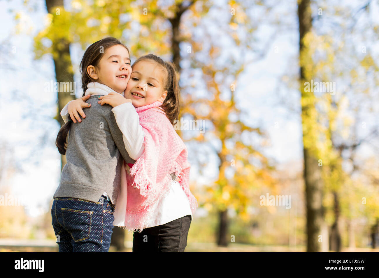 Cute little girls in the autumn park Stock Photo - Alamy