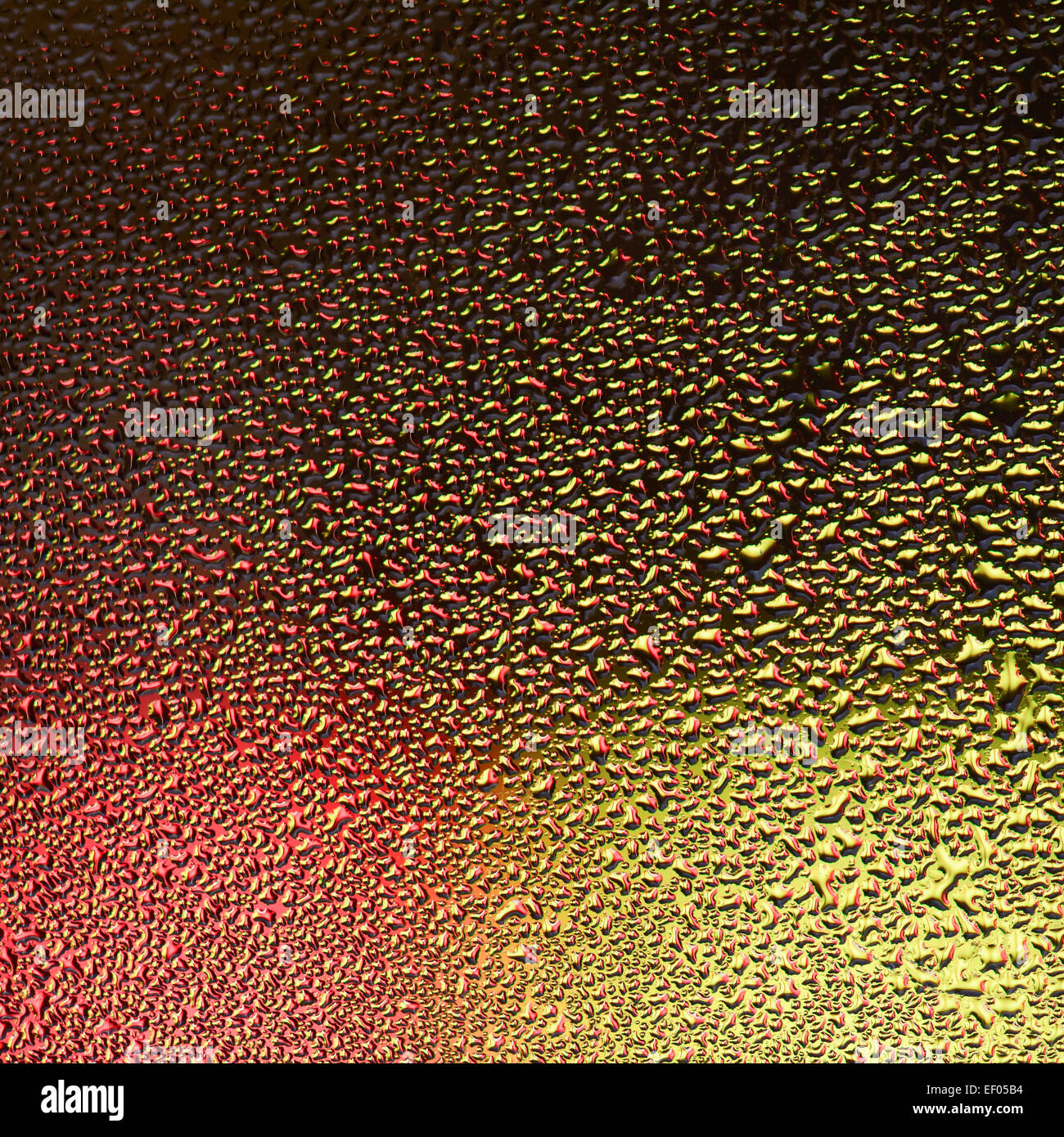 Water drop pattern on window with red and yellow colour background Stock Photo