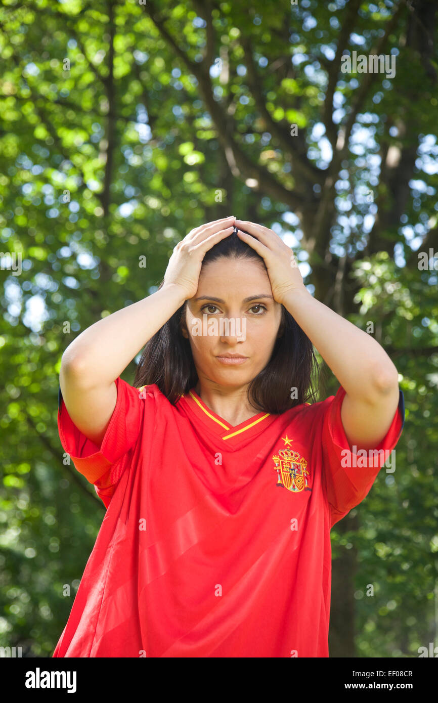 young woman with red spanish football team shirt unhappy Stock Photo