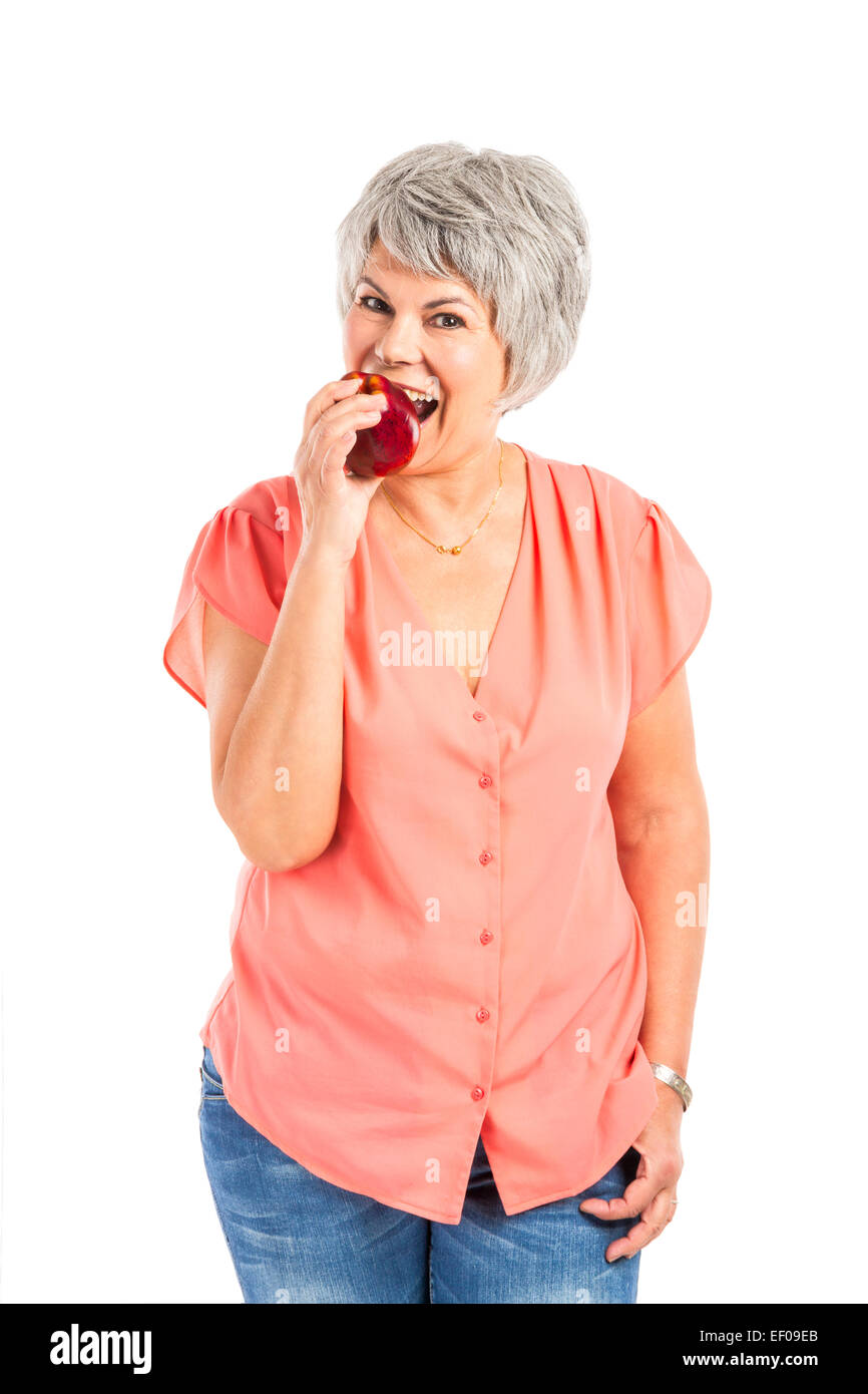 Portrait of a elderly woman eating a red apple Stock Photo