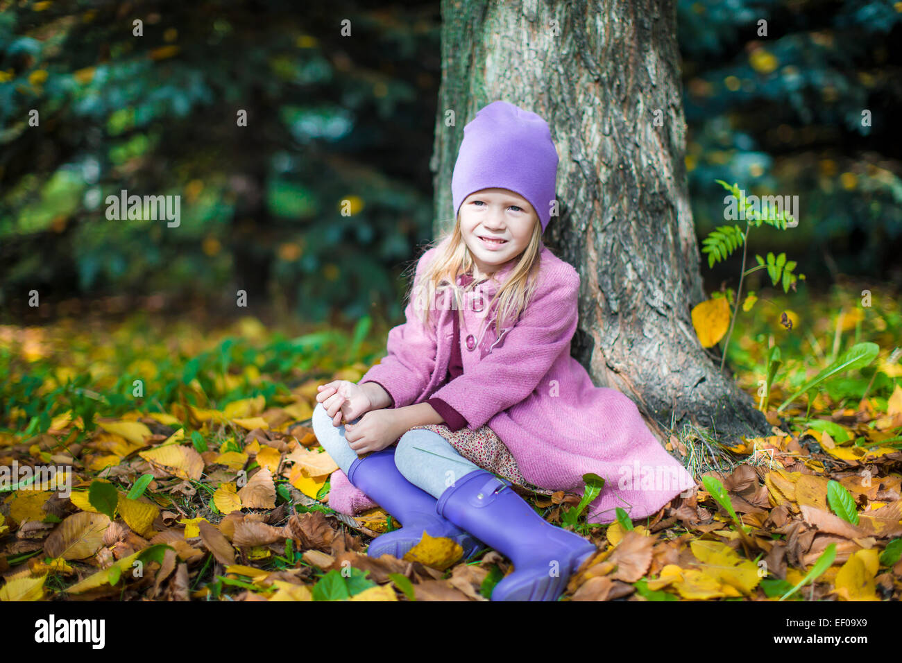 Little happy girl in autumn park on sunny fall day Stock Photo - Alamy