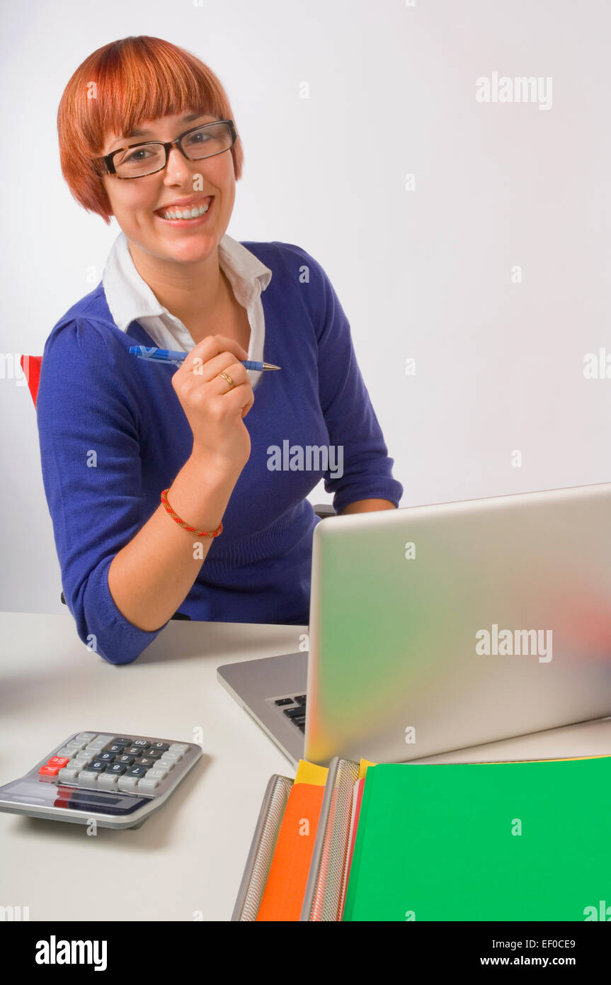 Happy businesswoman sitting at her desk Stock Photo - Alamy