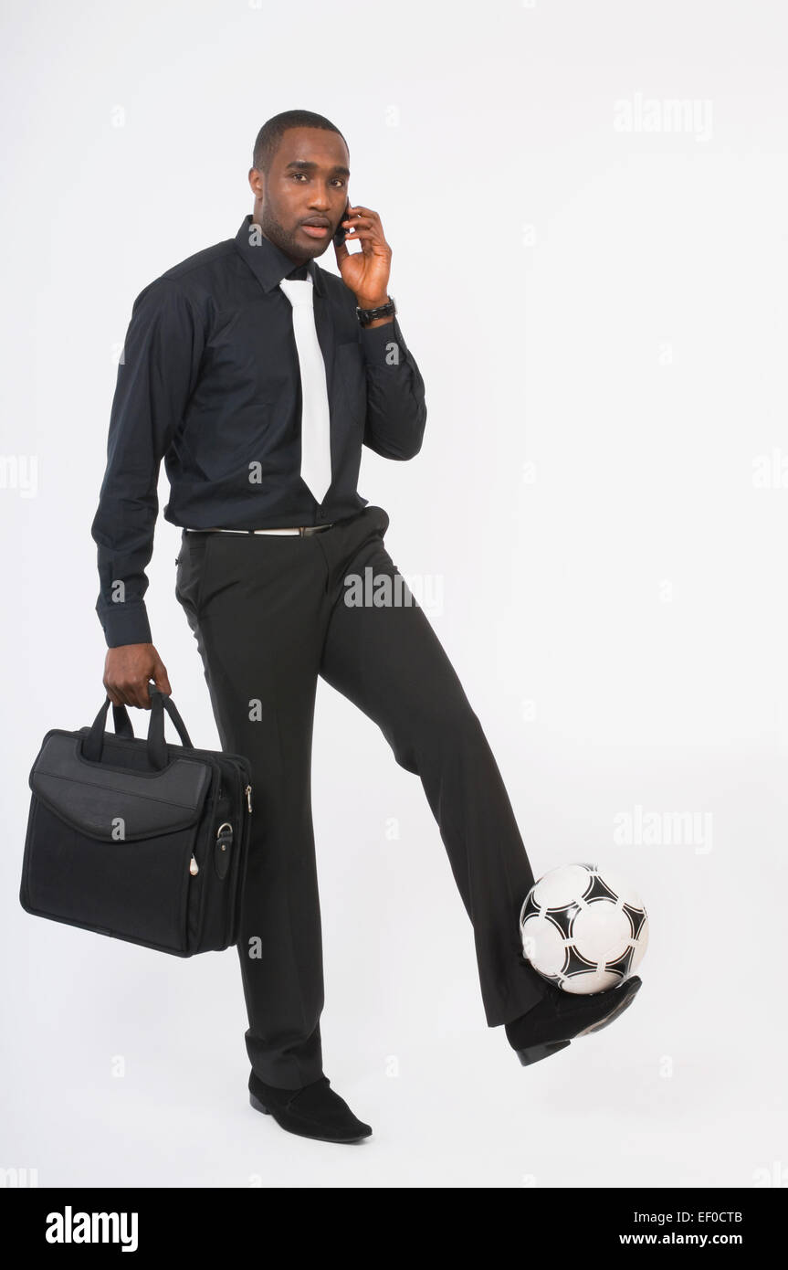 Businessman kicking a soccer ball Stock Photo - Alamy