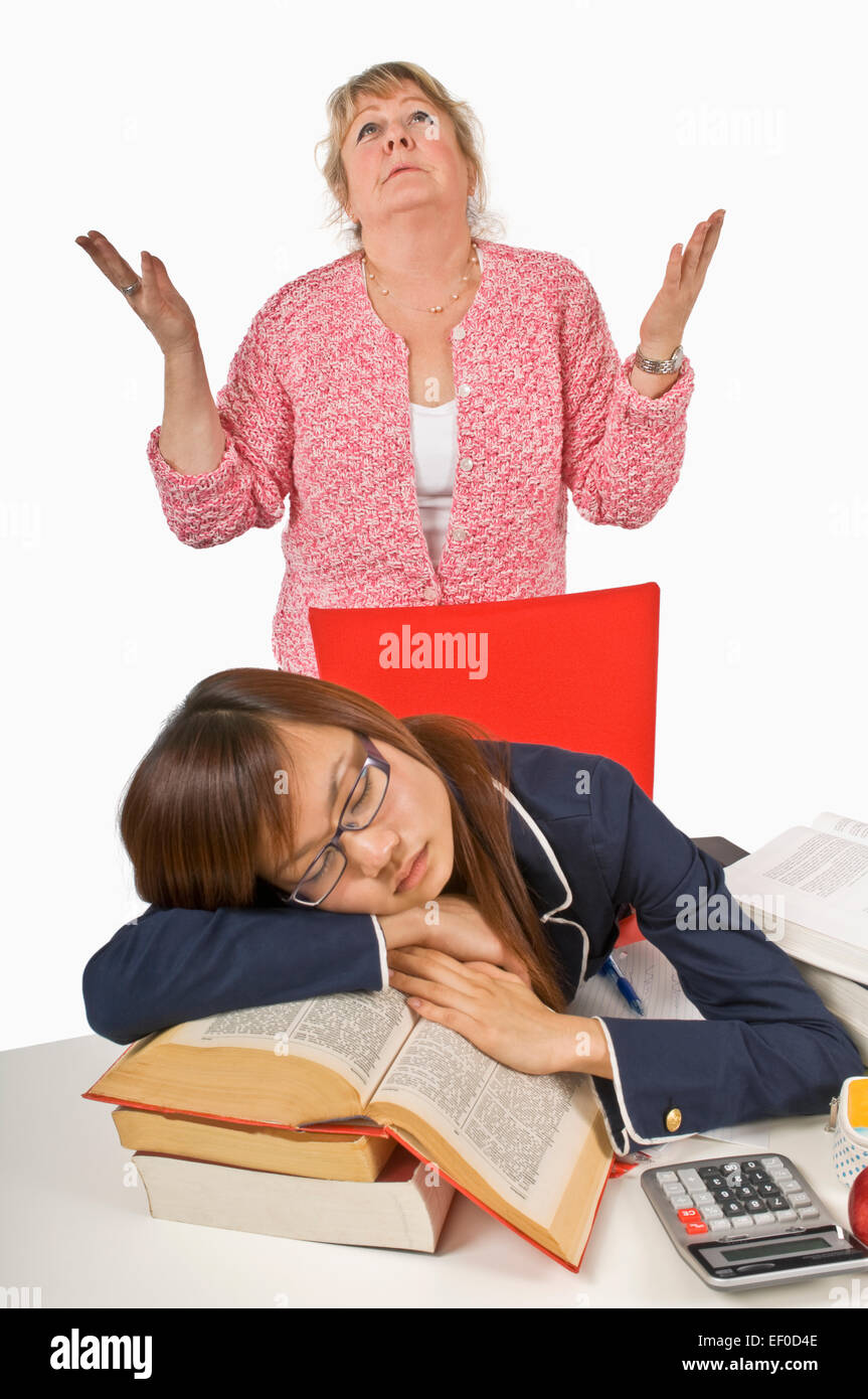 Frustrated teacher standing behind sleeping student Stock Photo