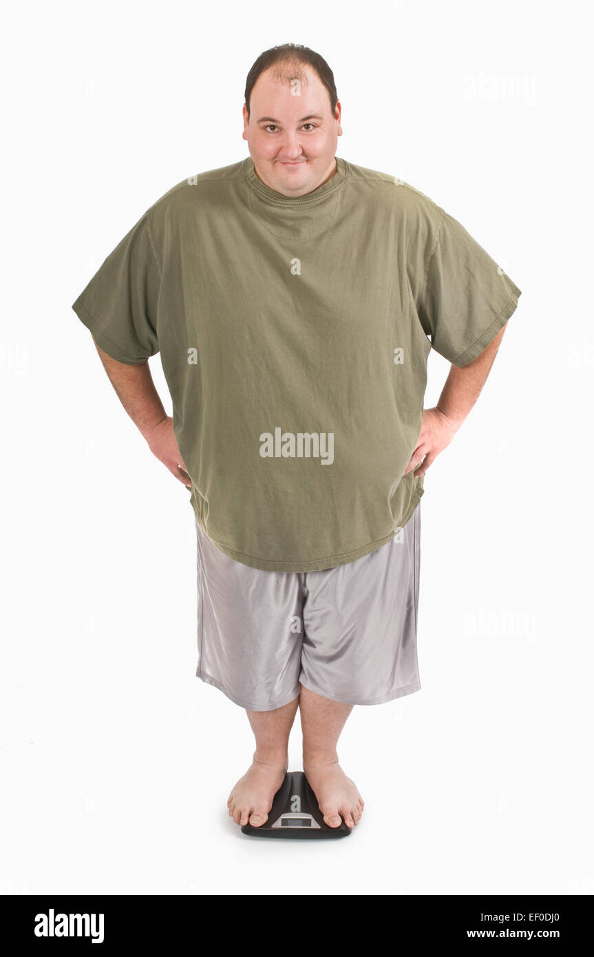 Overweight man standing on a scale stock photo alamy
