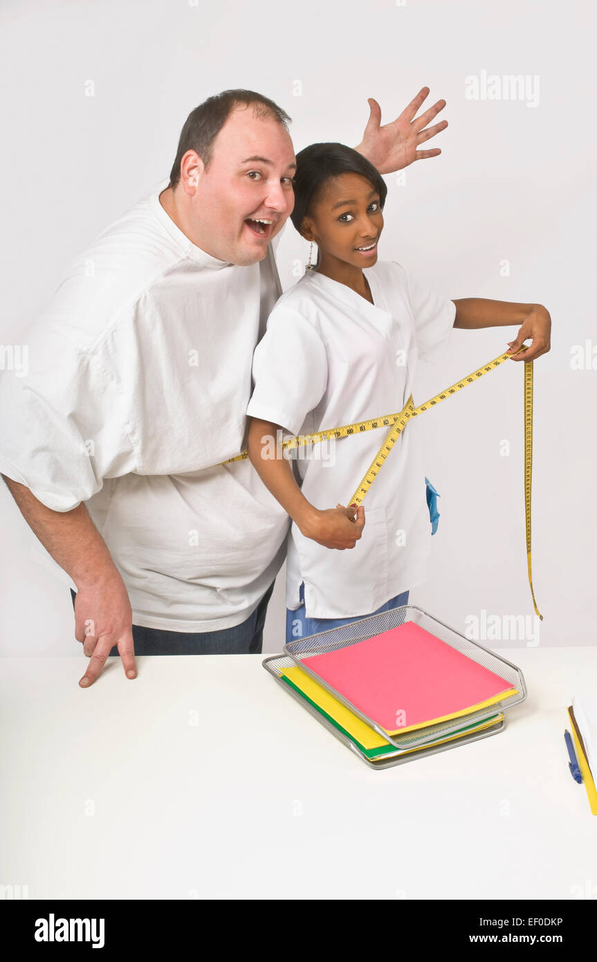 Nurse and patient measuring their midriffs at the same time Stock Photo