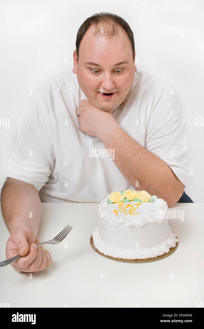 Overweight man looking at cake Stock Photo