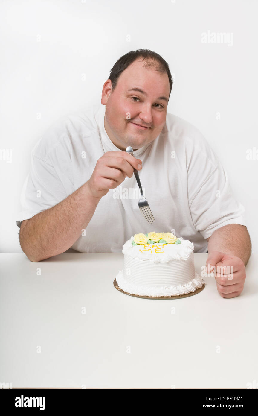 Overweight man about to eat a cake Stock Photo