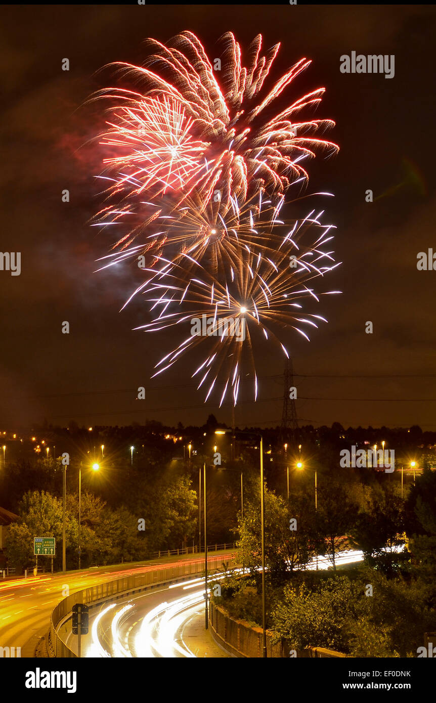 Firework display on November 5th with the streaked lights of cars on the A12 road underneath Stock Photo