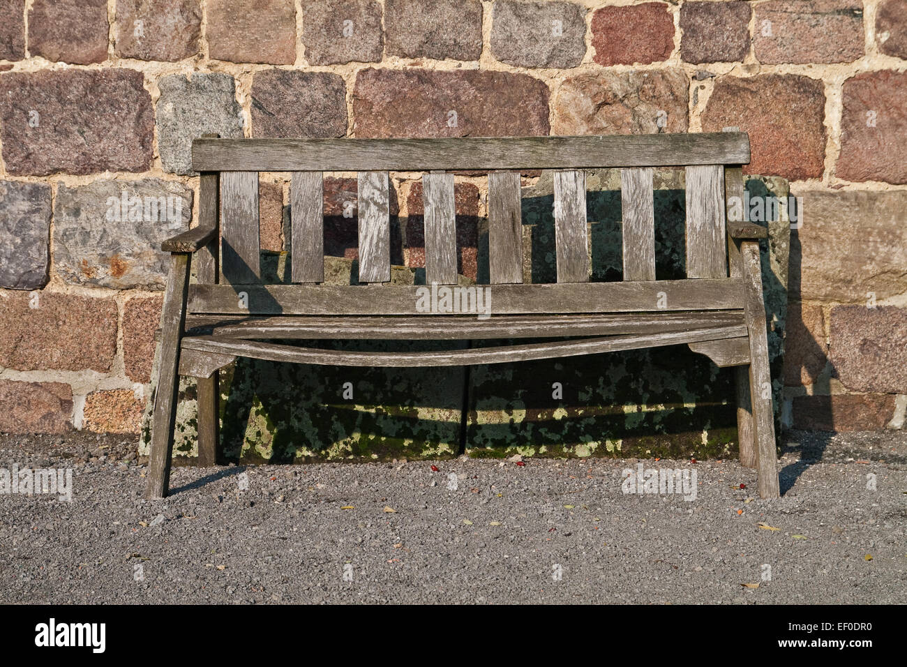 An old bench in front of a wall Stock Photo - Alamy