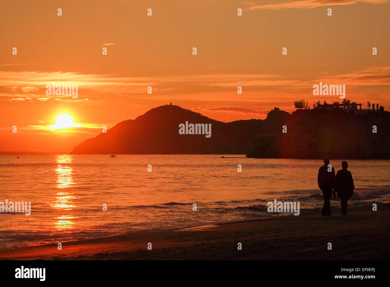 Benidorm sunset, orange with sea, sand, silhouettes and clouds Stock Photo