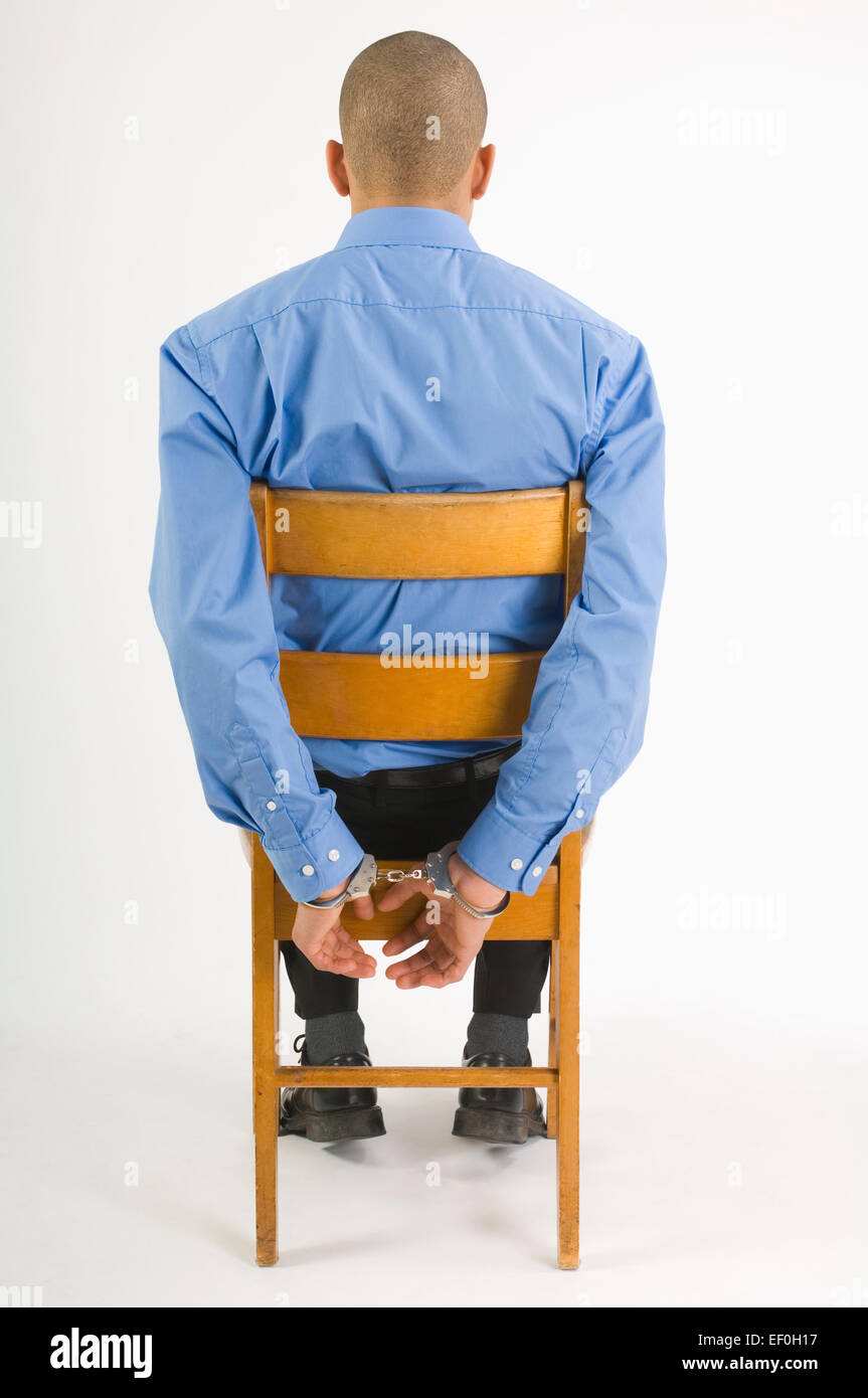 [Image: handcuffed-man-sitting-in-chair-EF0H17.jpg]