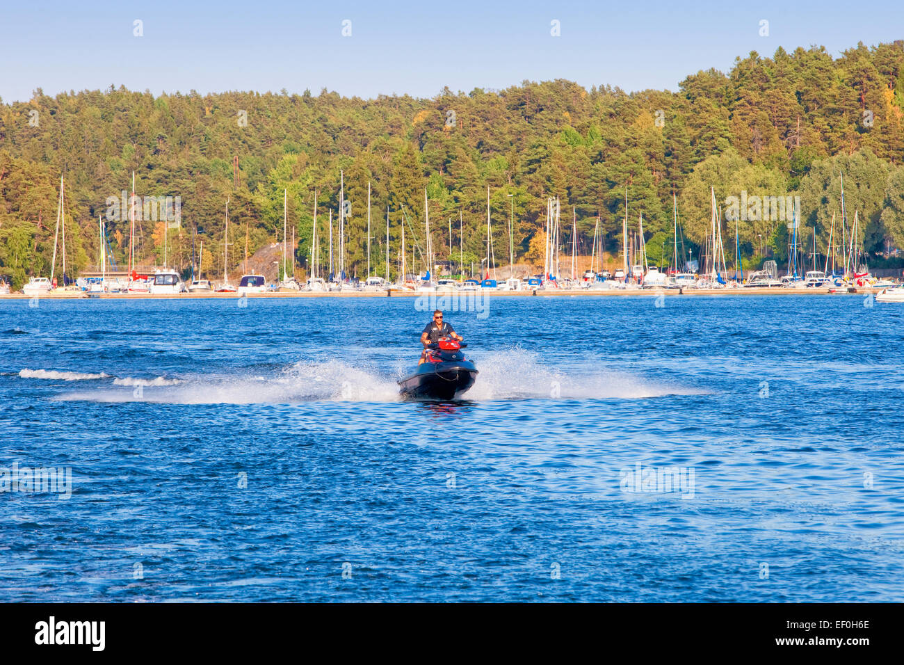 Sweden, Stockholm - Man riding personal watercraft jet ski in archipelago. Stock Photo