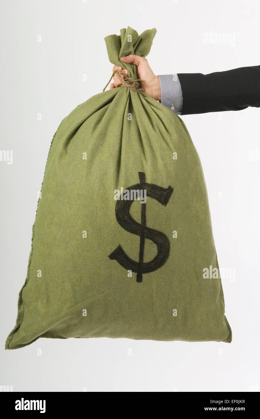 An arm holding a bag of money Stock Photo