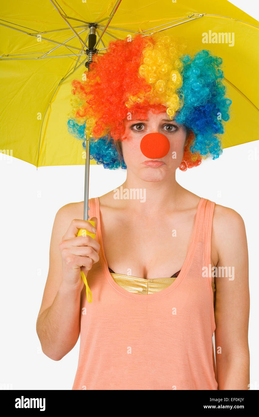 Woman wearing clown wig and holding yellow umbrella Stock Photo - Alamy