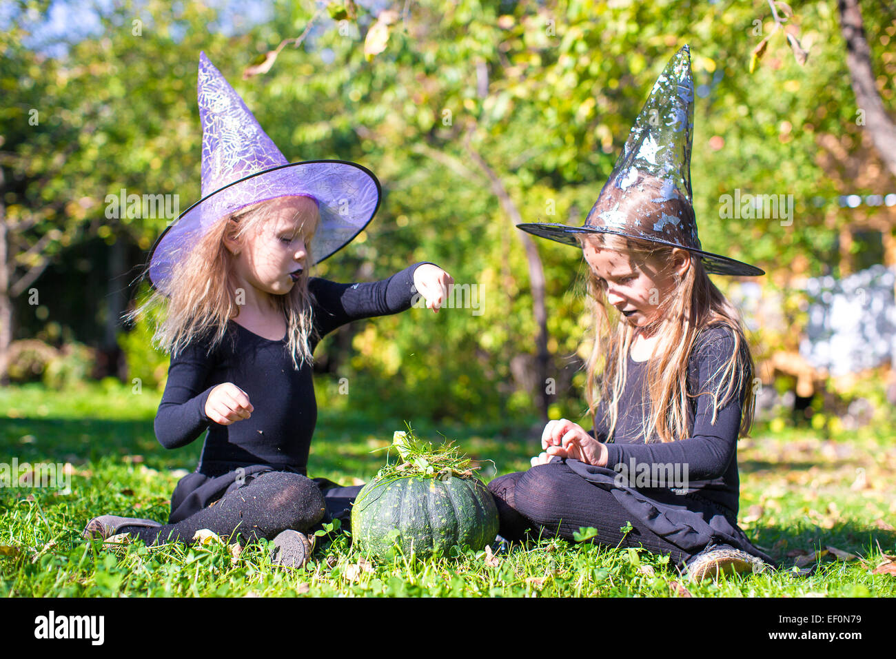 Adorable little girls in witch costume casting a spell on Halloween ...