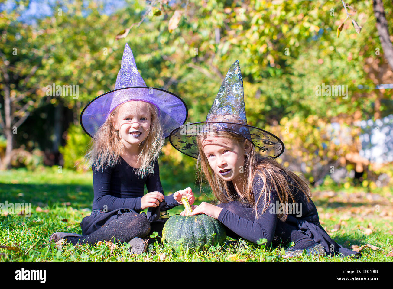 Adorable little girls in witch costume casting a spell on Halloween ...