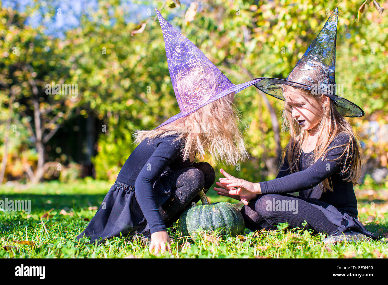 Adorable little girls in witch costume casting a spell on Halloween ...