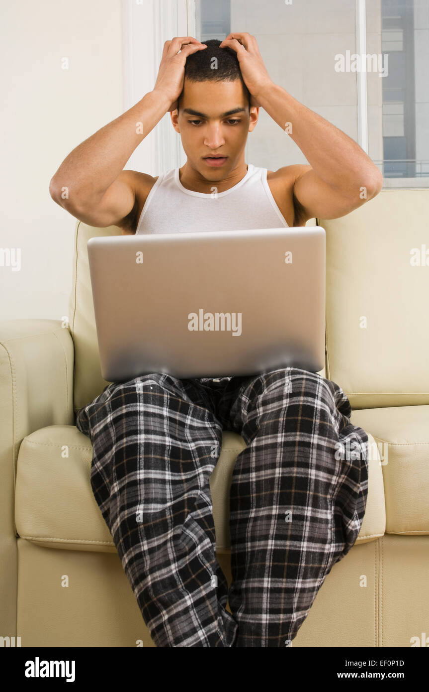Frustrated man looking at laptop Stock Photo