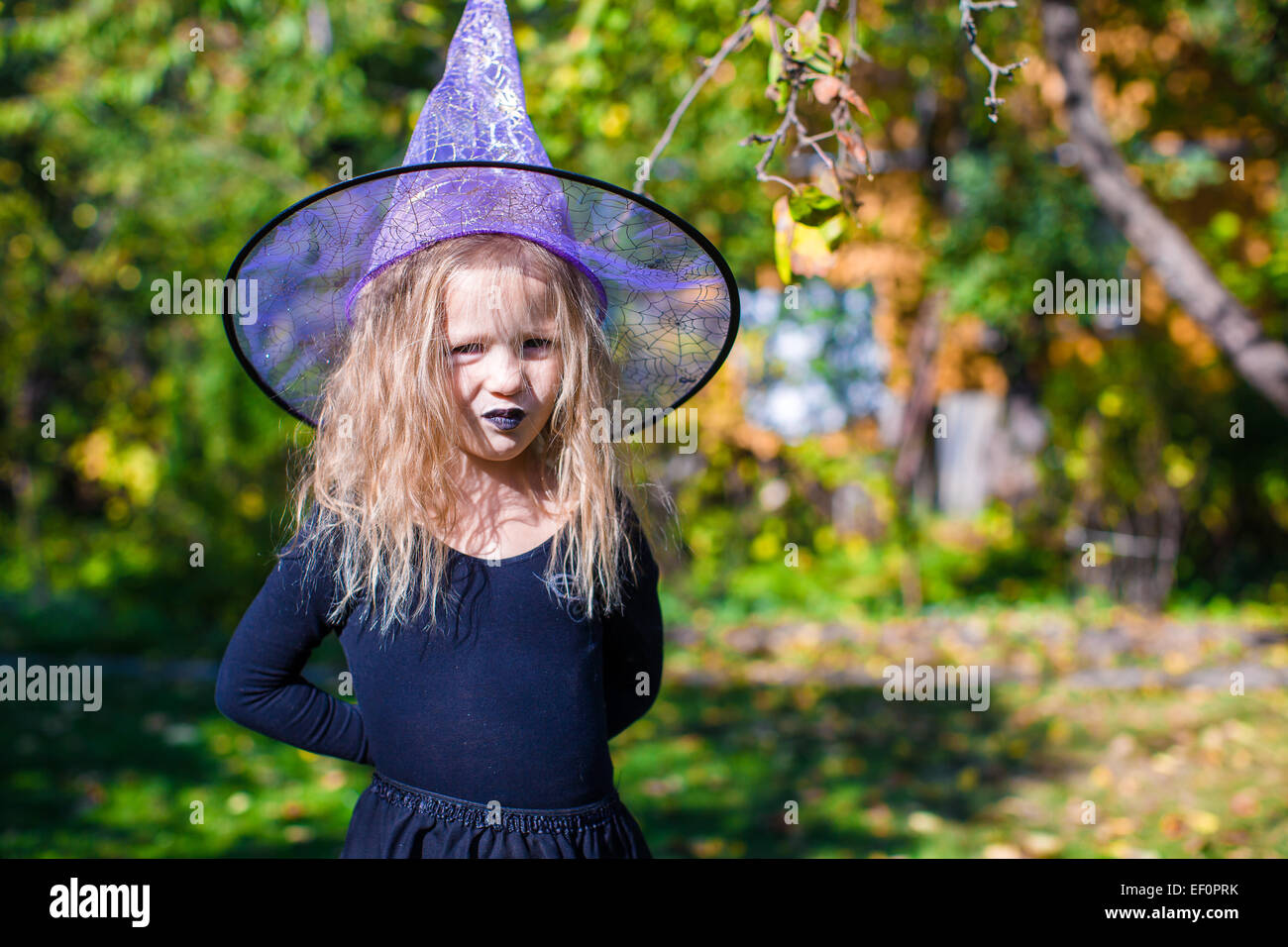 Adorable little girl in witch costume casts a spell on Halloween Stock ...
