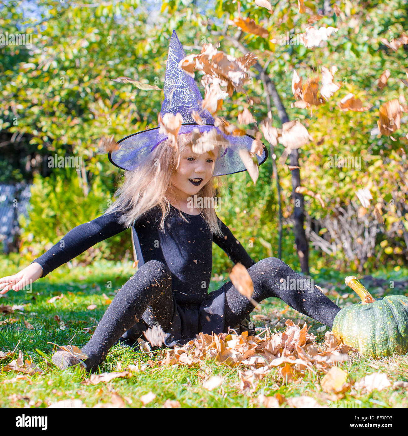 Adorable little girl in witch costume casts a spell on Halloween Stock ...