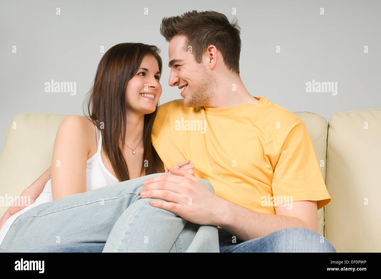 Couple embracing on couch Stock Photo