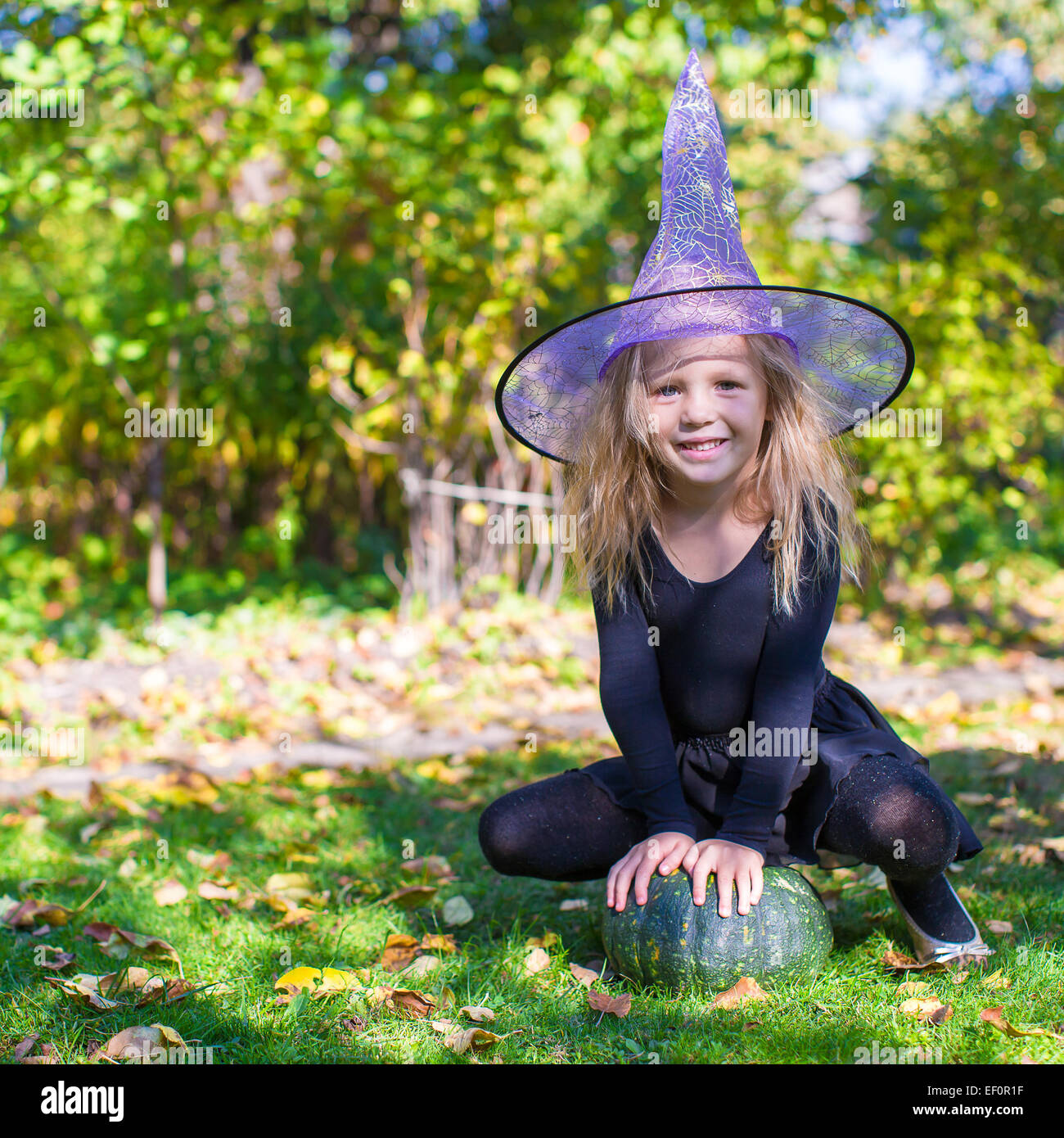 Adorable little girl in witch costume casts a spell on Halloween Stock ...