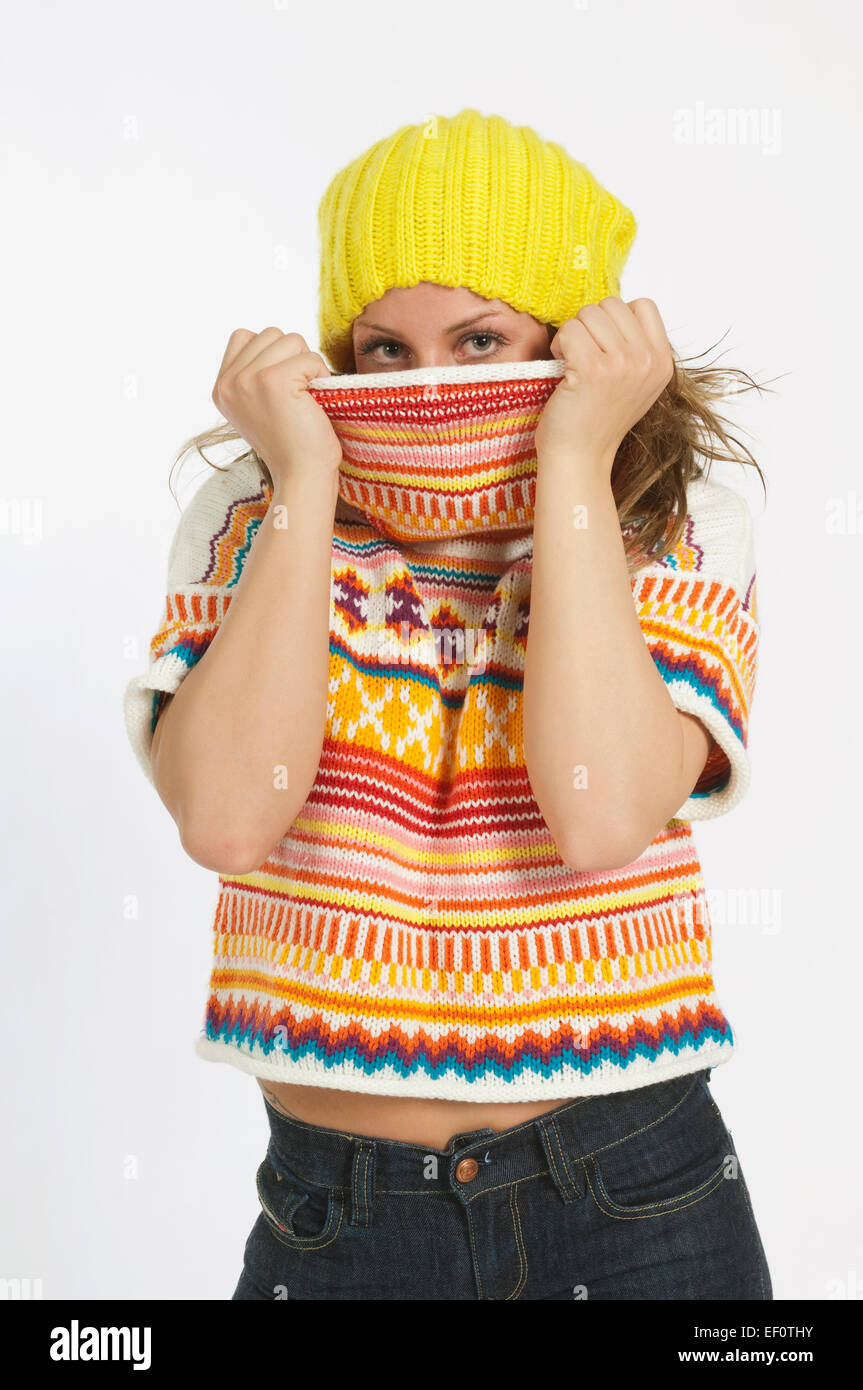 Woman pulling turtle neck sweater over her face Stock Photo