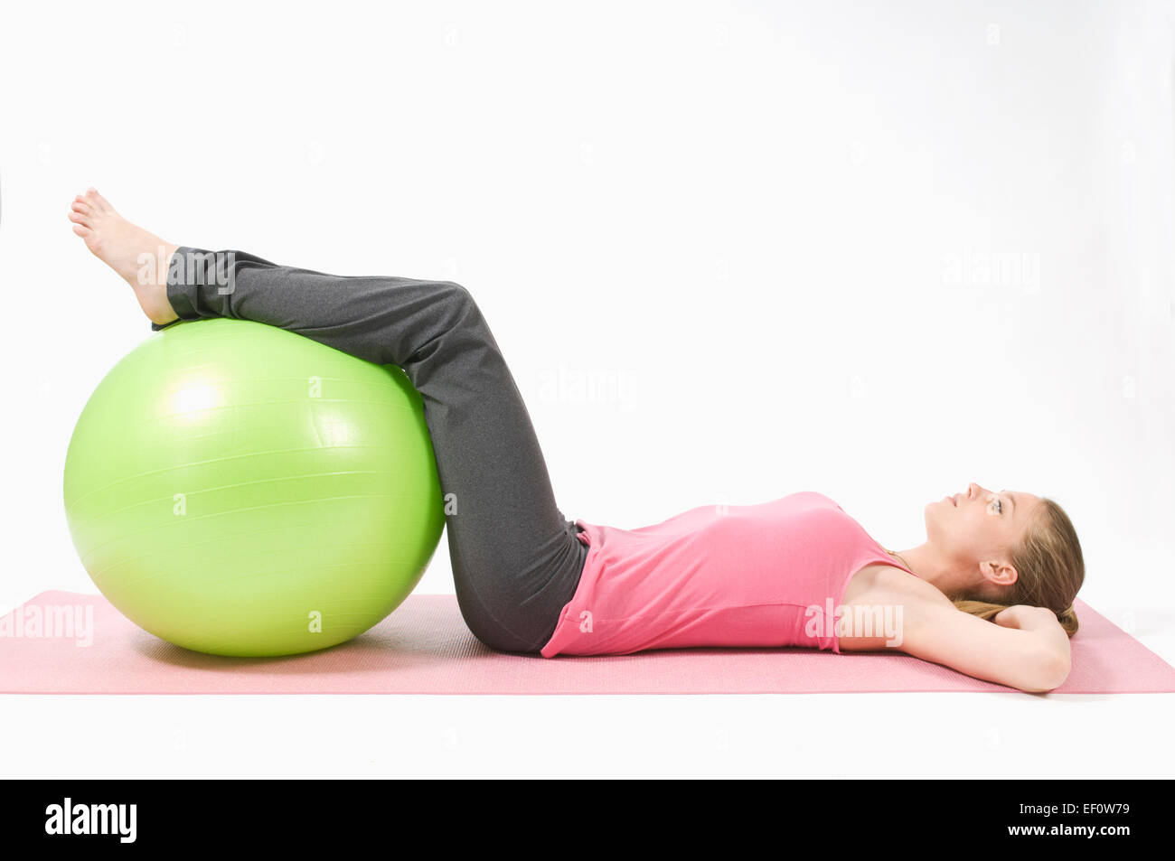 Woman with her legs on exercise ball Stock Photo