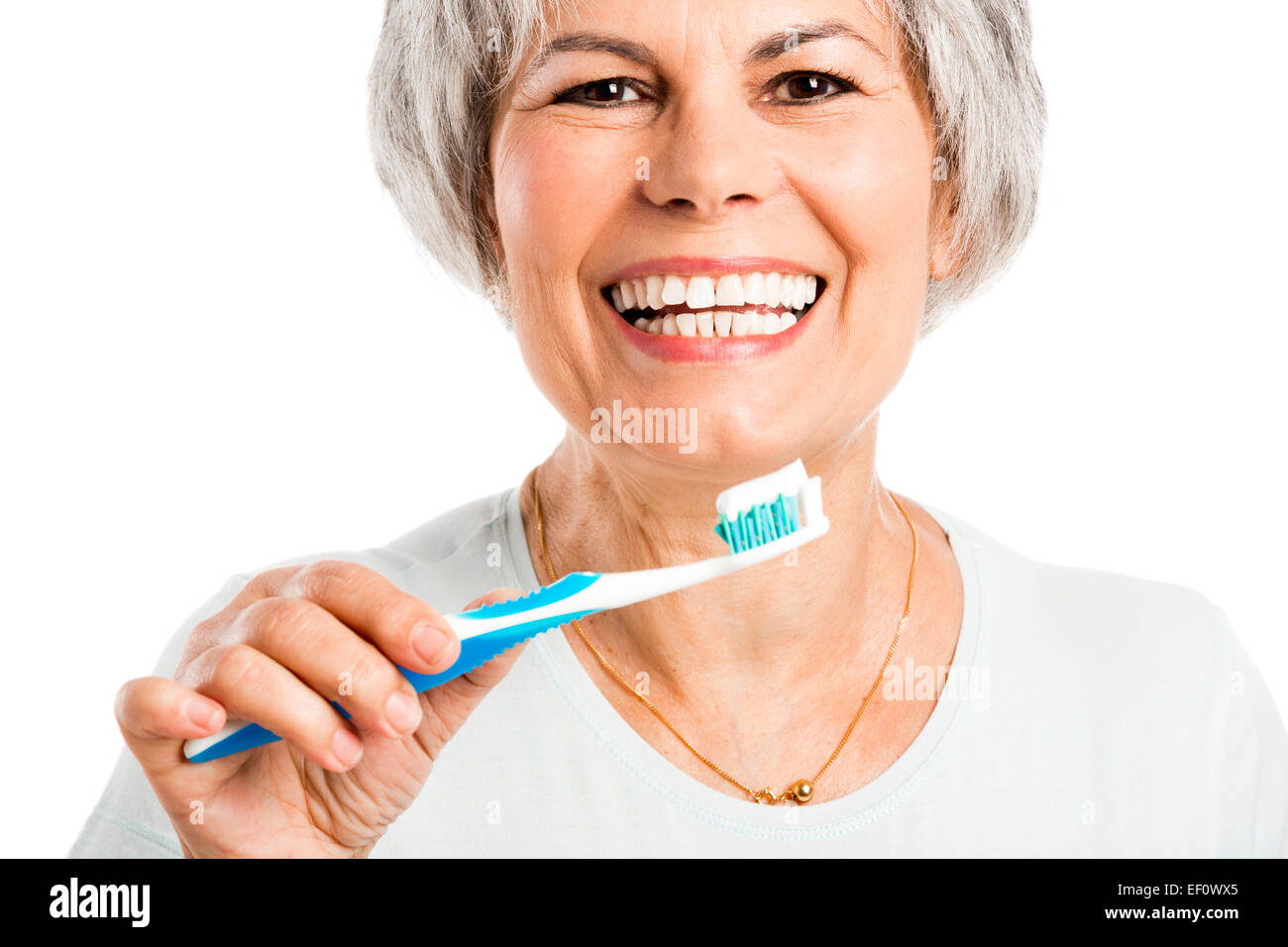 Portrait of a happy old woman brushing her teeth Stock Photo