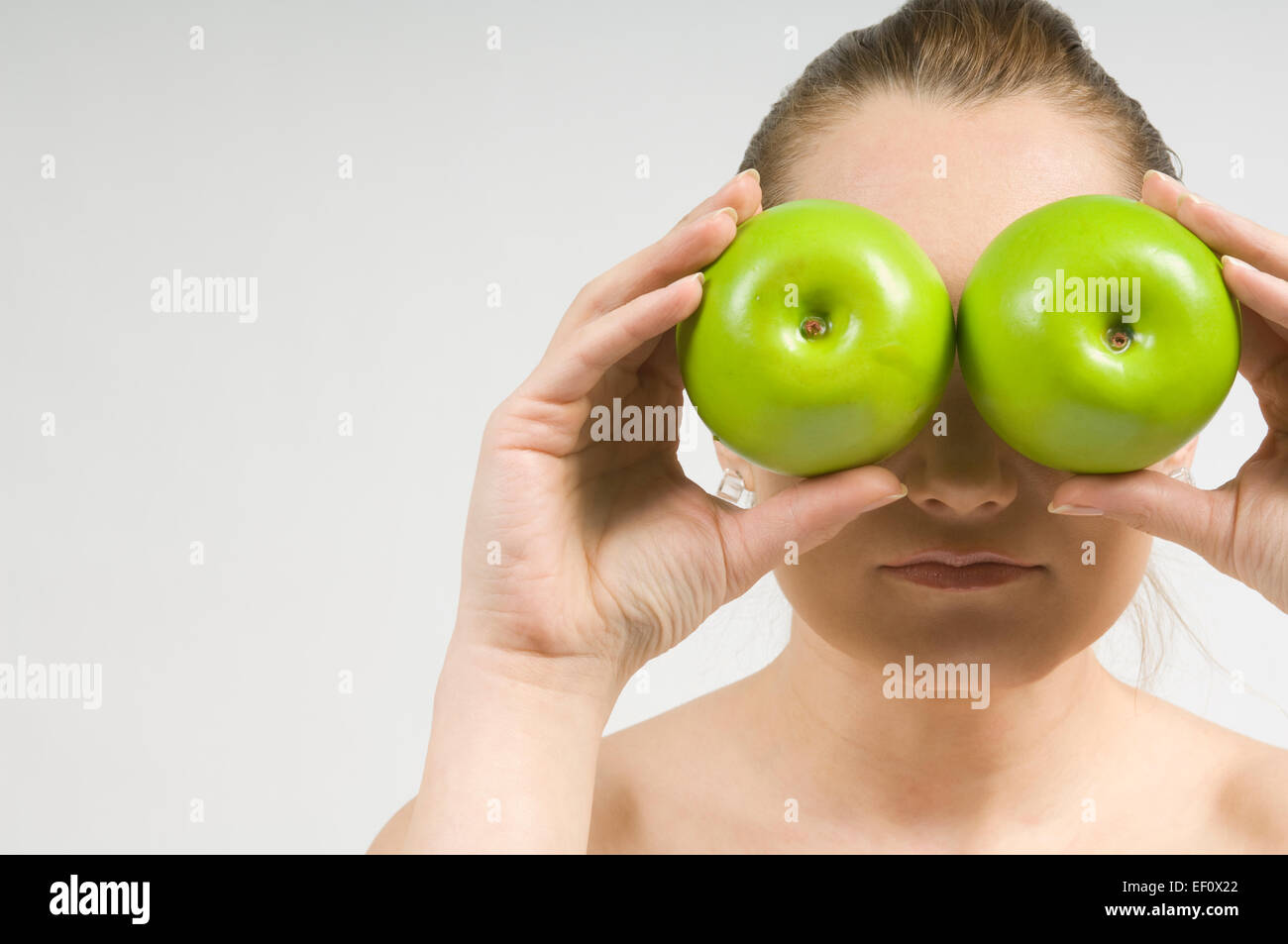 Woman holding apples in front of her eyes Stock Photo