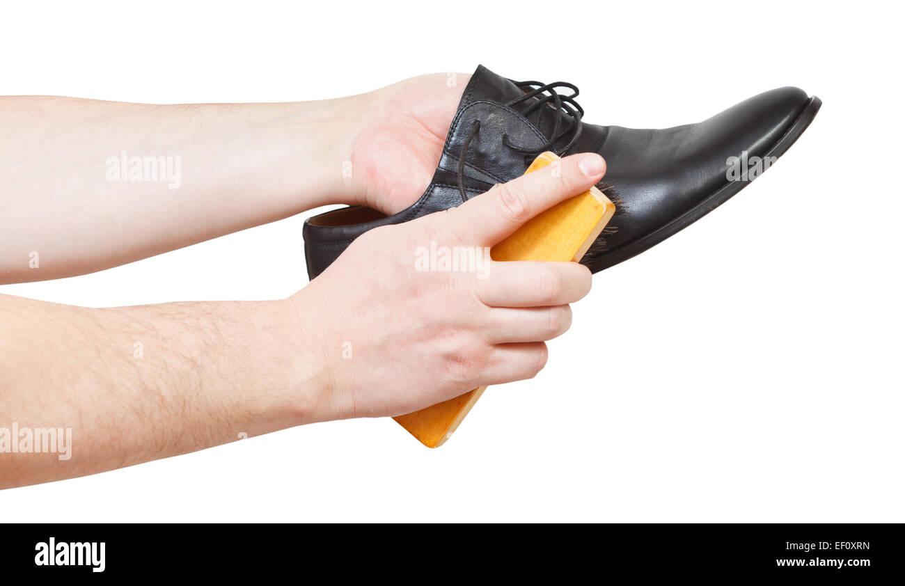 Shoeshiner brushing black shoe by brush isolated on white background Stock Photo