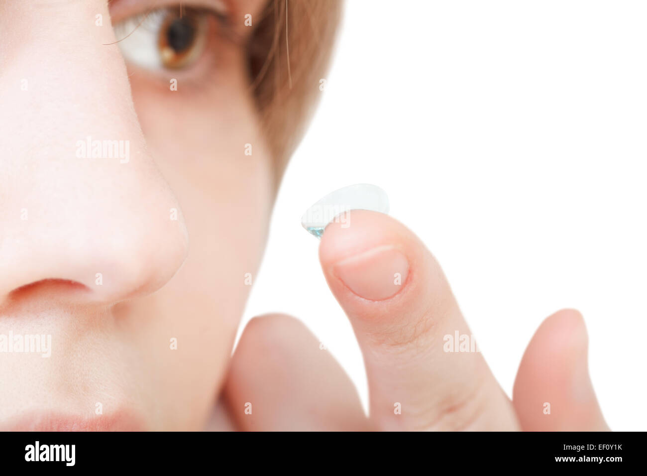 girl inserts corrective lens in eye close up Stock Photo