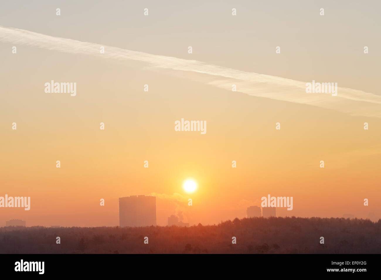 orange sunrise sky over city in cold winter morning Stock Photo