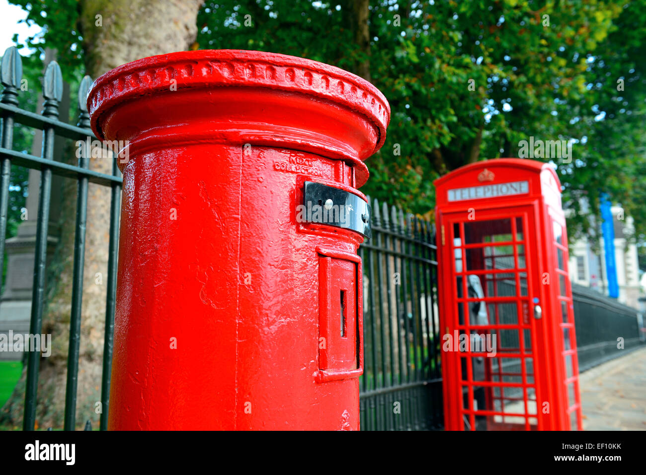 Red telephone and post box in street with historical architecture in ...