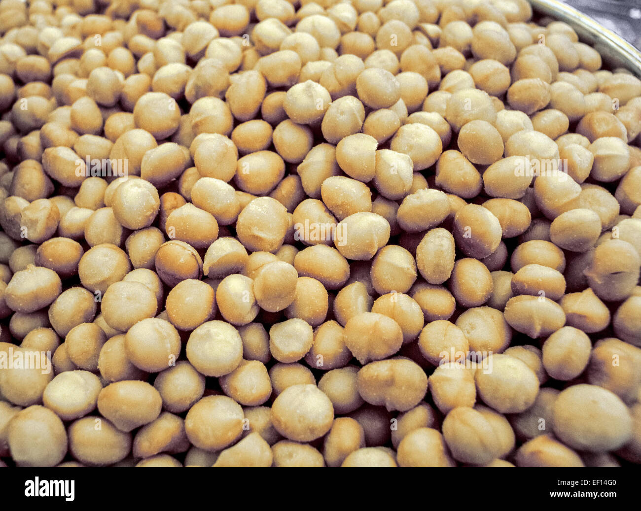 Roasted and salted macadamia nuts in a big silver bowl await guests at