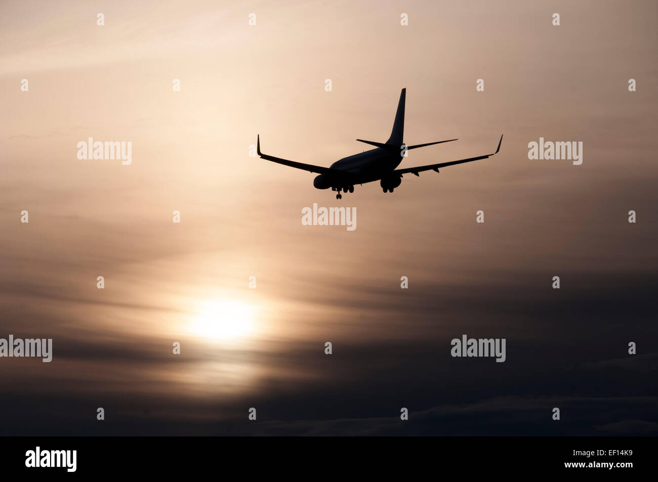 Silhouette of commercial jet making final approach, with backdrop of ...