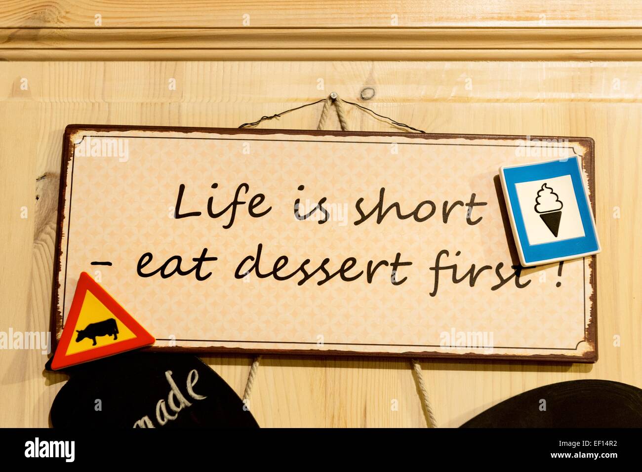 Life is short - eat dessert first.  Sign hanging outside an ice-cream parlour, on a farm in Iceland. Stock Photo