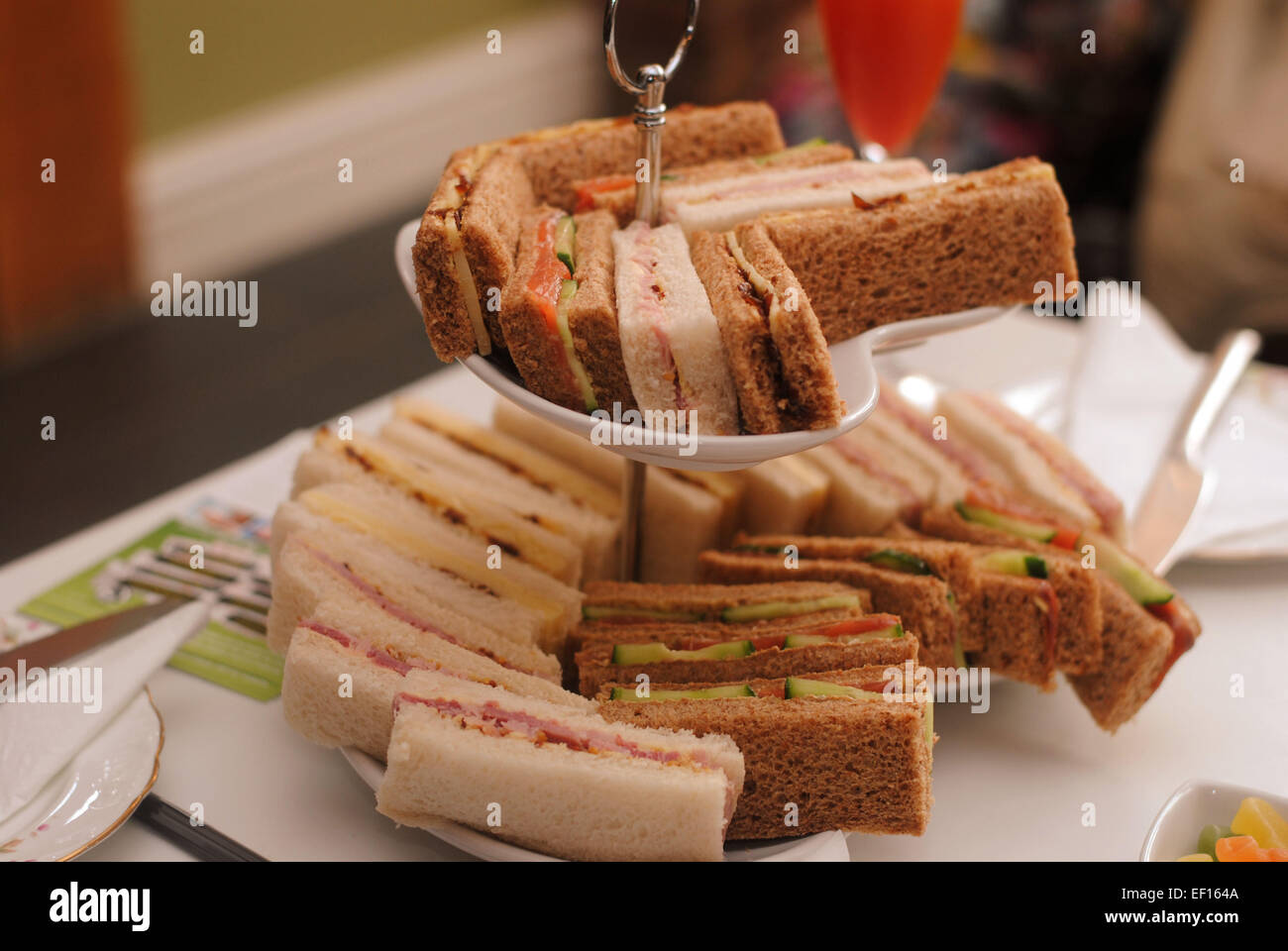 Finger sandwiches on a cake stand in an English afternoon tea. Stock Photo