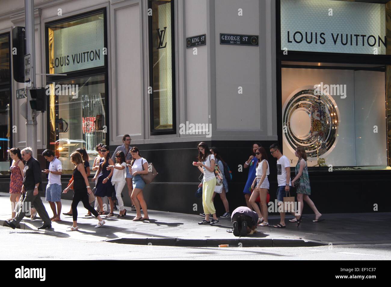 A man begs outside the Louis Vuitton store on George Street
