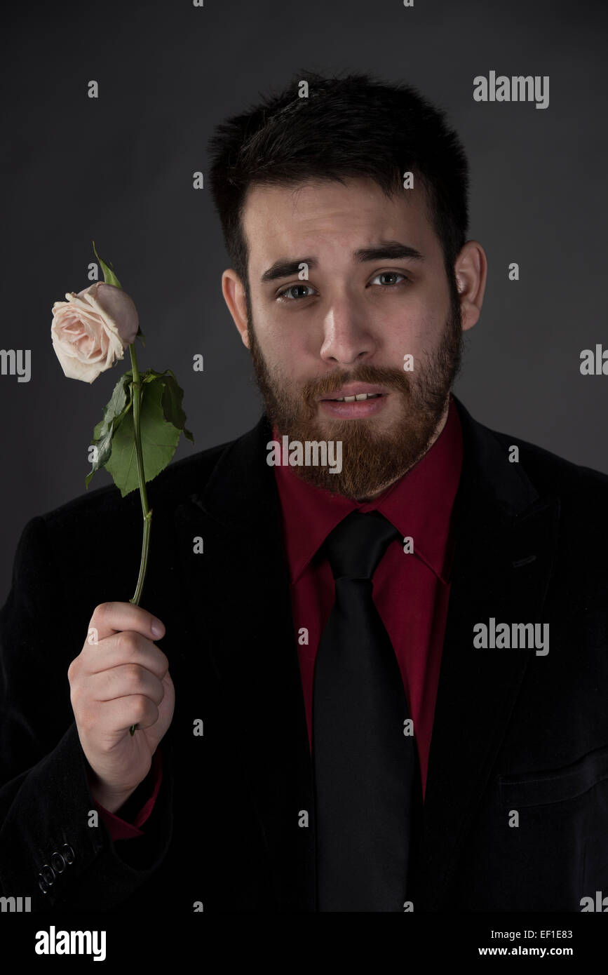 Sad Man in Formal Wear Holding Withered Rose Stock Photo