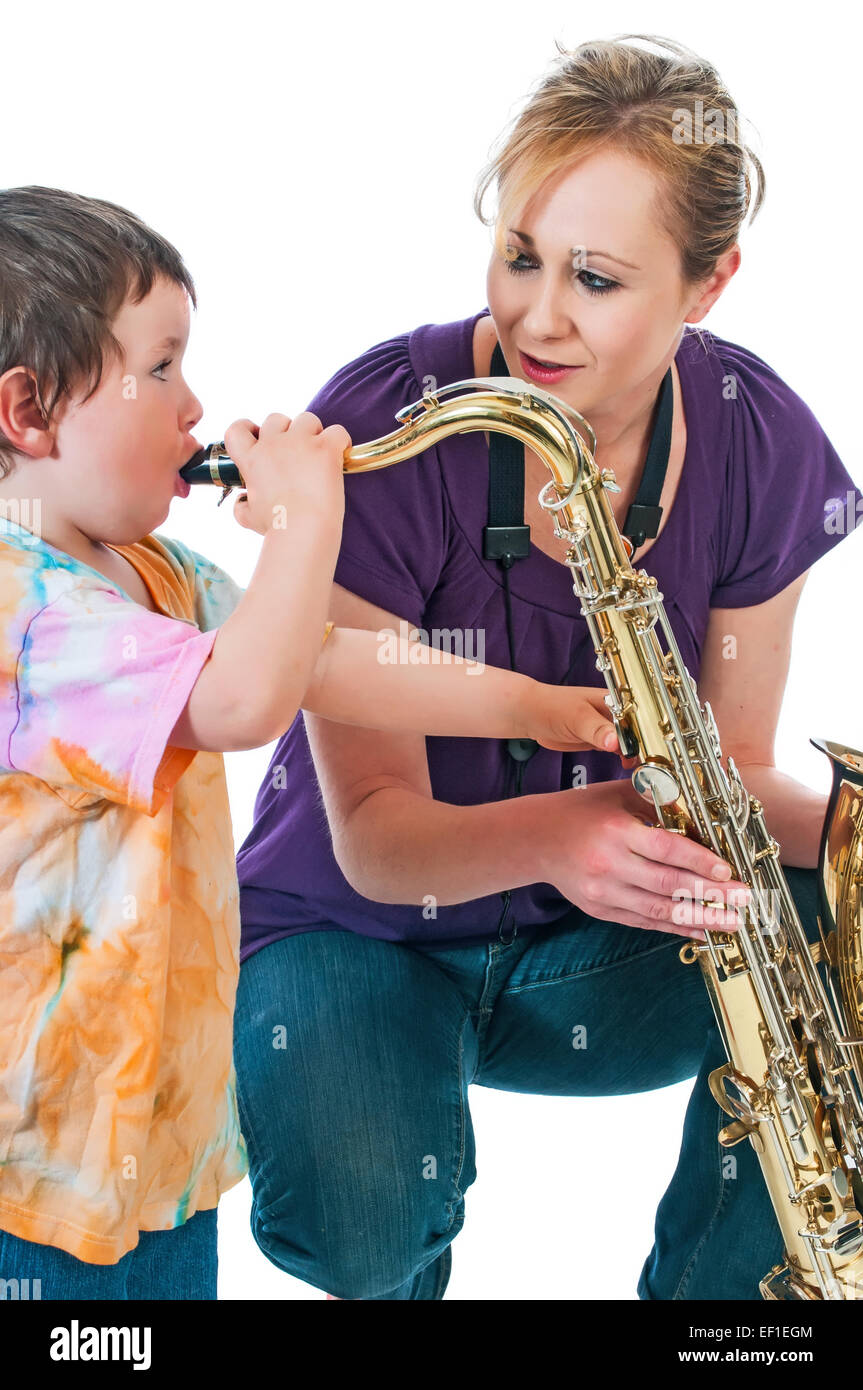 Little boy having fun pretending to play a saxophone. Isolated on a white background. Stock Photo