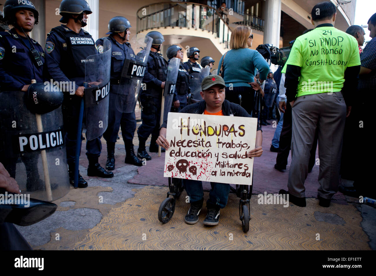 (150125) -- TEGUCIGALPA, Jan. 25, 2015 (Xinhua) -- A supporter of the political party "Libertad y Refundacion", whose leader is former Honduran President, Jose Manuel Zelaya Rosales, holds a banner during the celebration of the constitutional non-ratification of the Military Police of Public Order (PMOP), in front of the National Congress, in Tegucigalpa city, Honduras, on Jan. 24, 2015. The Honduran Congress rejected on Saturday the proposal of the Executive Branch to grant constitutional rank to the PMOP, during the closing of the sessions of the first legislature. After the rejection of the Stock Photo