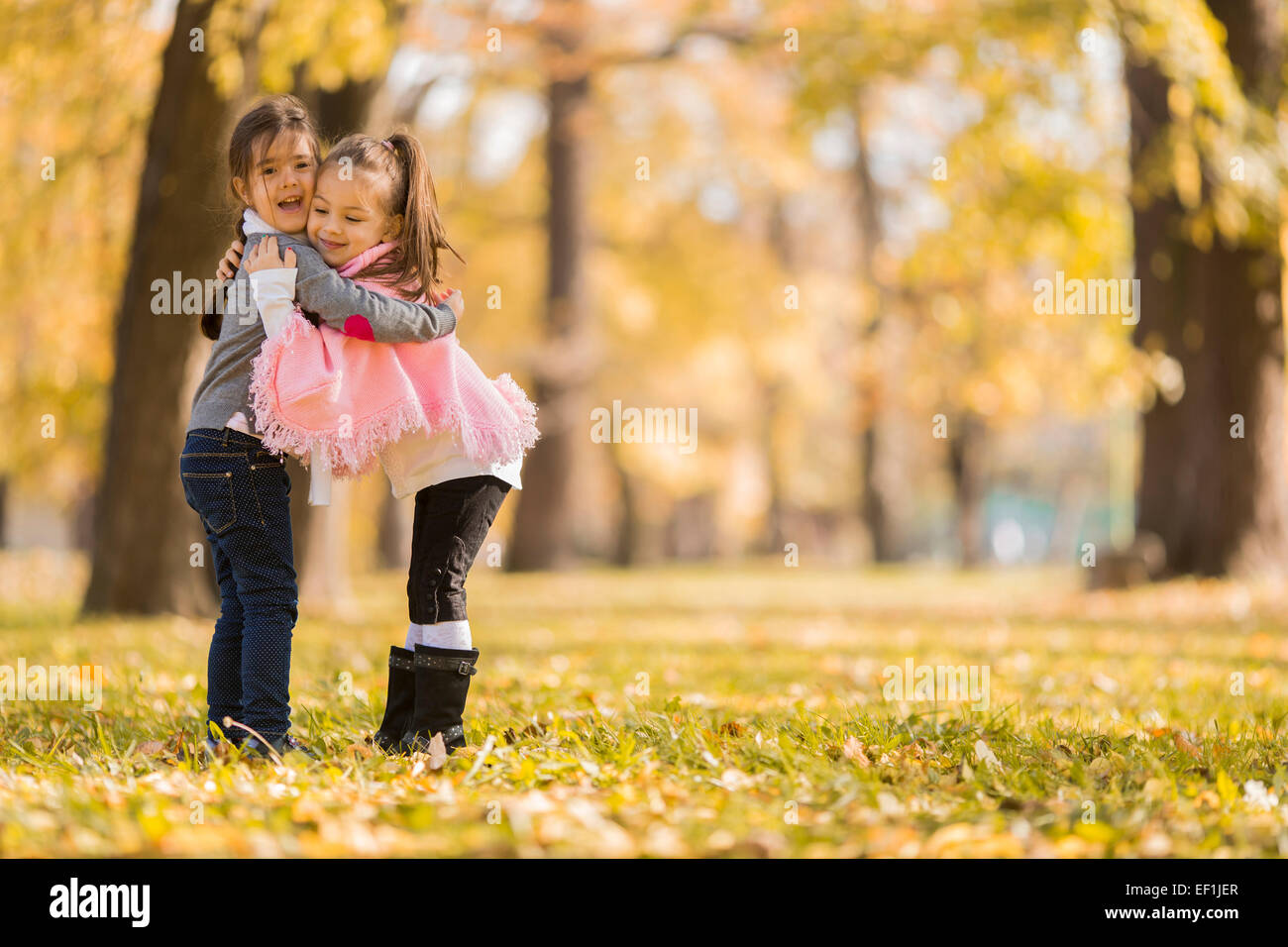 Cute little girls in the autumn park Stock Photo - Alamy