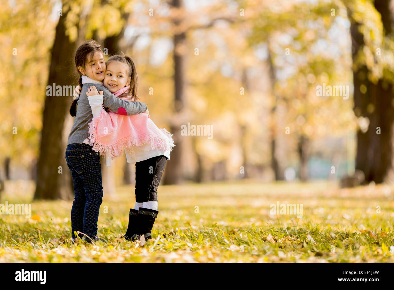 Cute little girls in the autumn park Stock Photo - Alamy