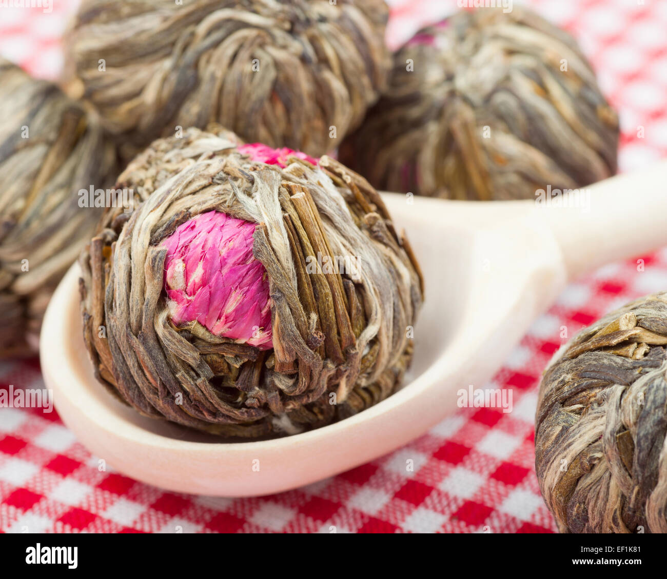Green tea balls with flowers in wooden spoon on kitchen table Stock ...