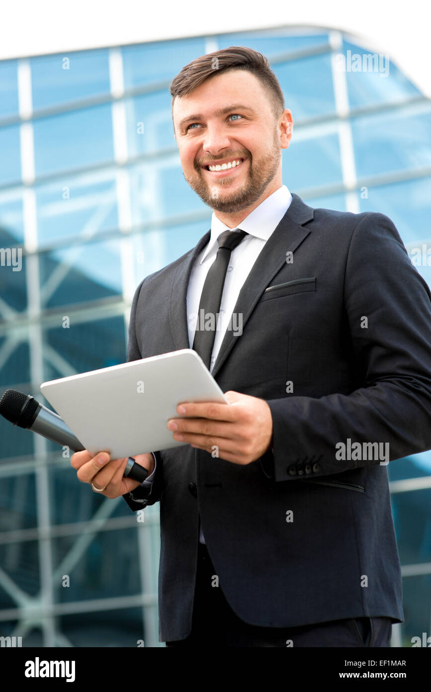 Toastmaster Microphone Toastmaster or newsmaker posing with microphone and digital tablet on ...