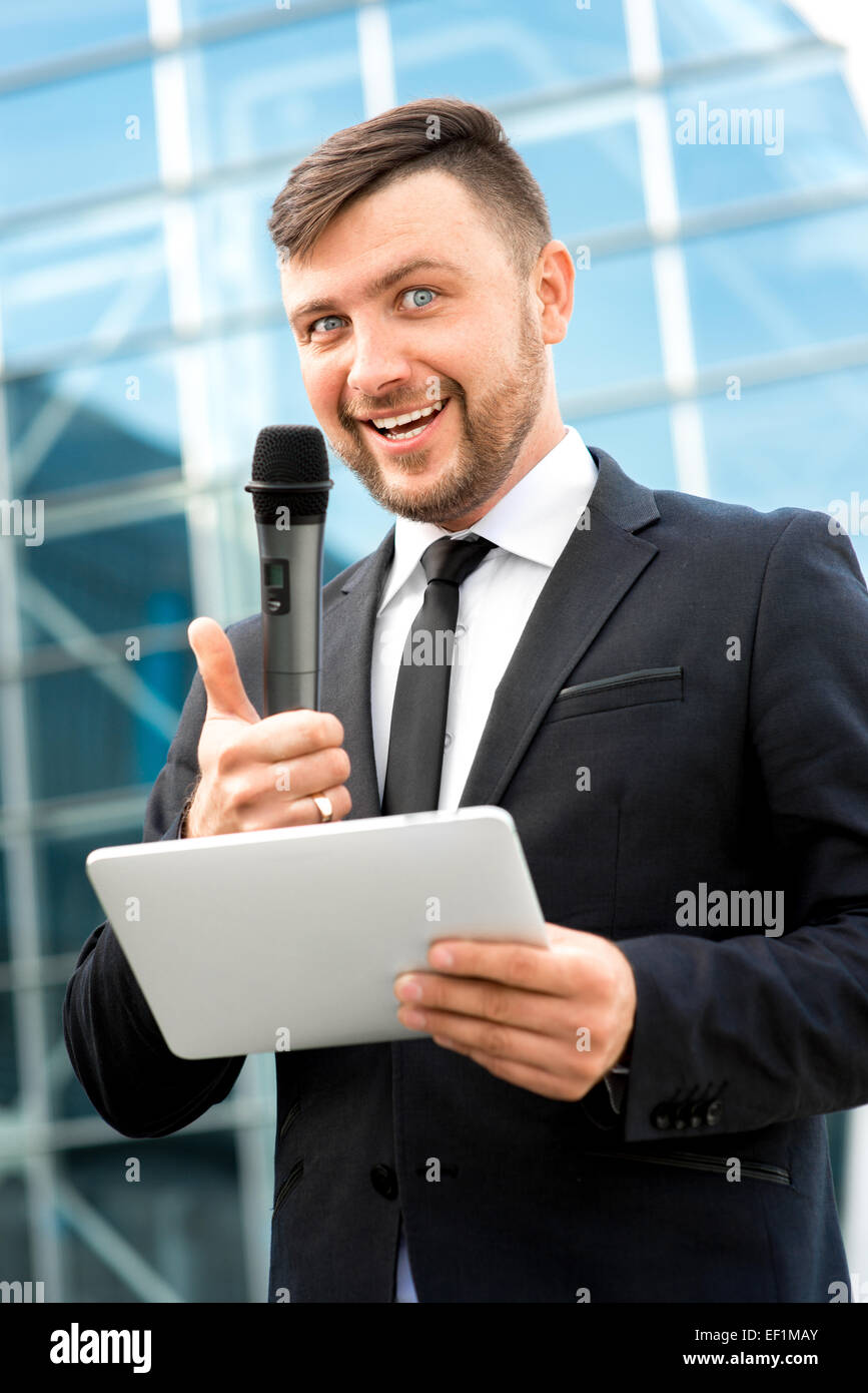 Toastmaster Microphone Toastmaster or newsmaker posing with microphone and digital tablet on ...